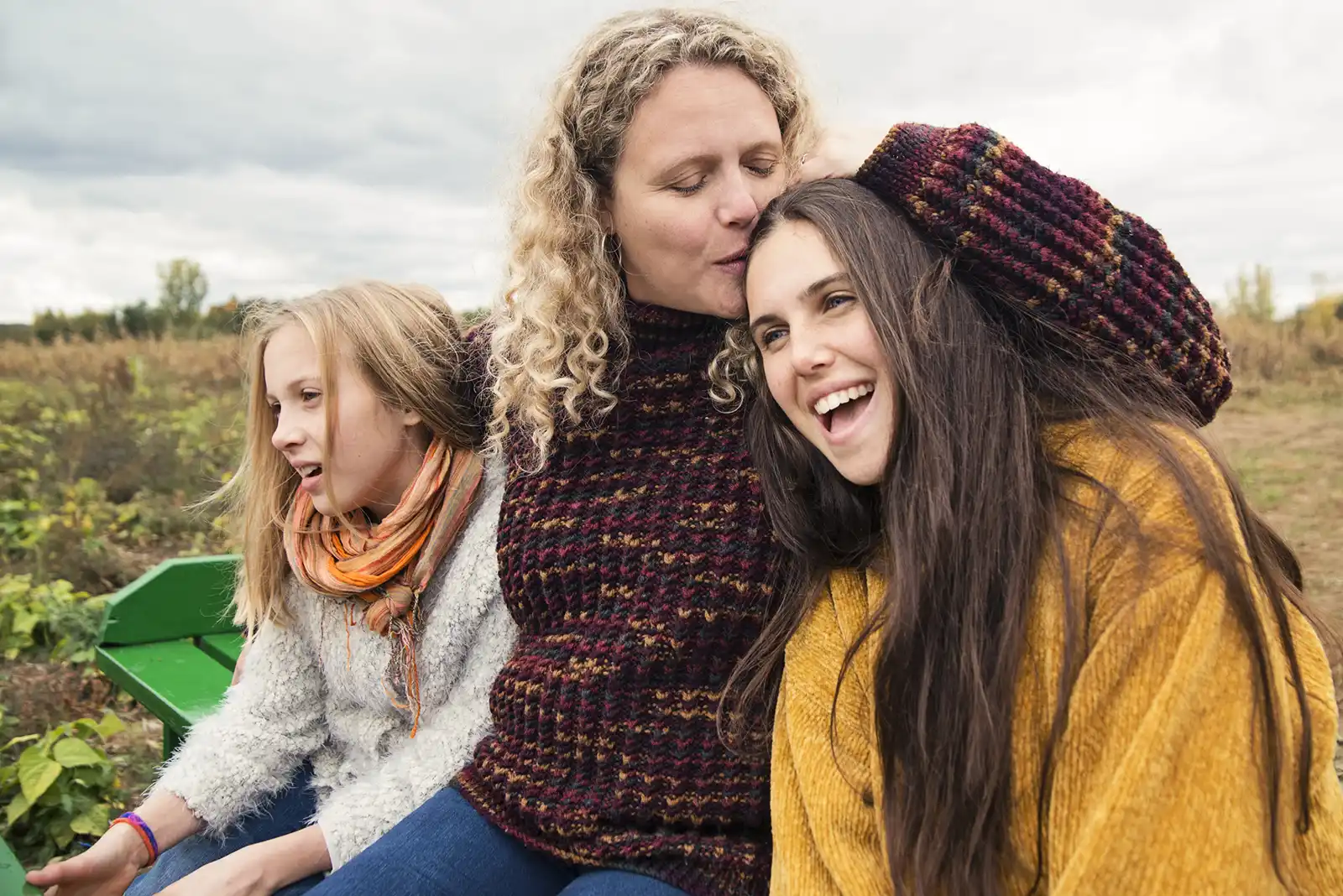 A mother hugs her two daughters