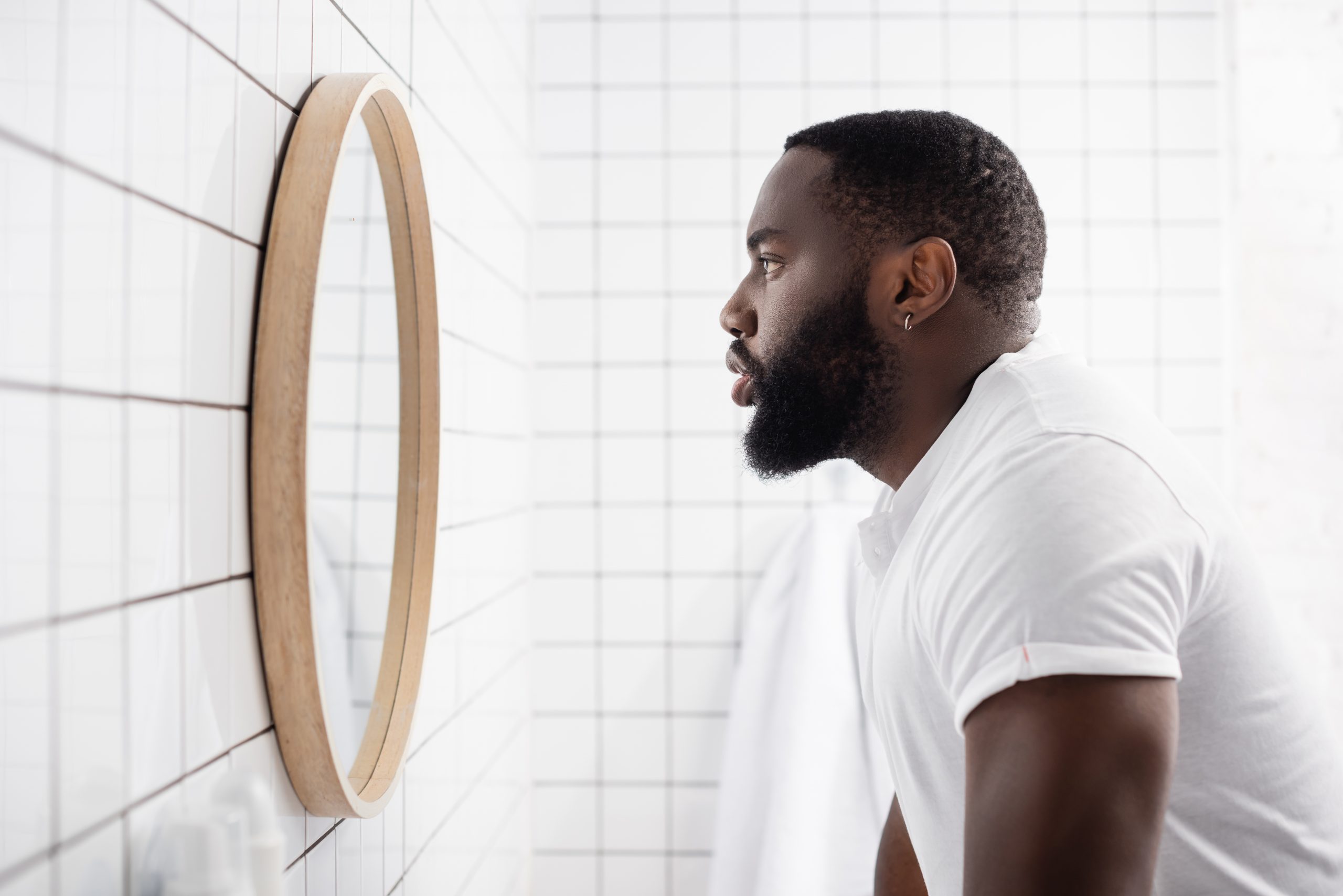 Side,View,Of,Serious,Afro-american,Man,Looking,In,Mirror